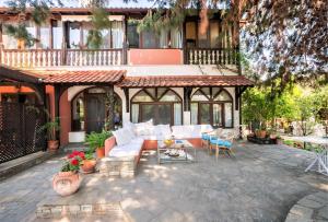 un patio al aire libre con sofás blancos y una mesa en Alterra Vita, en Neos Marmaras