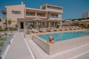 un ours en peluche assis sur une cornée à côté d'une piscine dans l'établissement Marble Luxury Suites, à Karteros