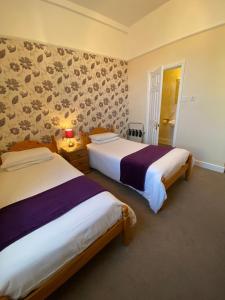 2 camas en una habitación de hotel con 2 camas sidx sidx sidx en Paignton Court, en Paignton