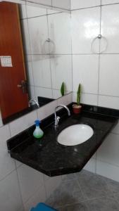 Diamantina Ecohostel في ديامانتينا: منضدة الحمام مع الحوض والمرآة