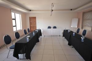 a conference room with a table and chairs in it at The Stone Guest House in Teyateyaneng
