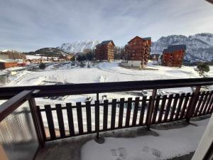 a balcony with snow on the ground and buildings at Studio superdevoluy in Le Dévoluy