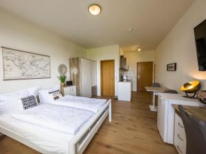um quarto com uma cama branca e uma cozinha em COZY 1-Zi-Whg Nähe Straßburg & Europa Park em Kehl am Rhein