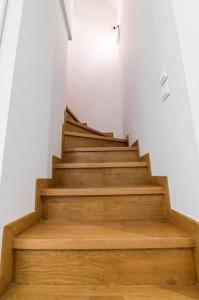 a staircase in a white room with wooden floors at Μεζονέτα με θέα στο πάρκο Σταύρος Νιάρχος TWO in Athens