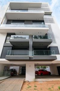 a building with a red car parked in front of it at Μεζονέτα με θέα στο πάρκο Σταύρος Νιάρχος TWO in Athens