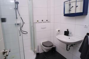 a bathroom with a toilet and a sink and a shower at Schöne 4-Bettzimmer Wohnung in Celle in Celle