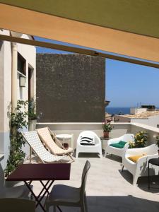 a balcony with chairs and a view of the ocean at Casa Helios in Castellammare del Golfo