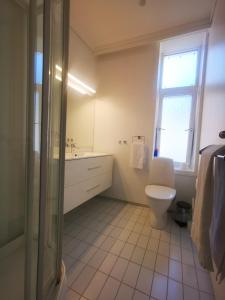 a bathroom with a toilet and a sink and a window at Inner City Center in Bergen +28 photos