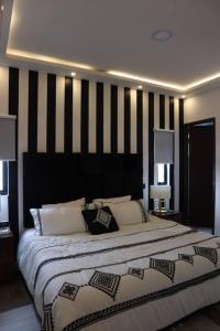 a bedroom with a large bed with black and white stripes at Luxurious and Central Apartment 2Br in Xalapa