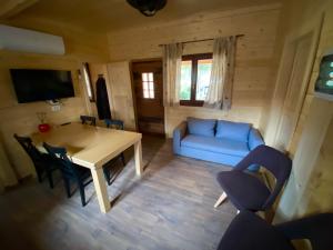 a living room with a table and a blue couch at Wooden lodge with jacuzzi in Rečica ob Savinji