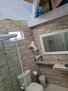 a bathroom with a toilet and a sink and a mirror at Casa para temporada, Centro de Ubatuba in Ubatuba +11 photos