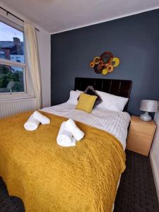 a bedroom with a large bed with towels on it at Stunning 3 bedroom near NG Hospital in Sheffield
