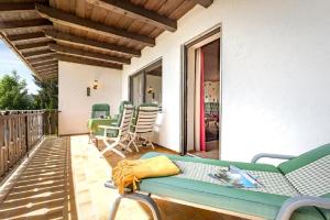 a patio with a couch and chairs on a balcony at Landhaus Keller in Bischofsmais