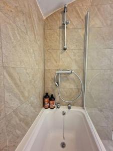 a bath tub in a bathroom with a shower at Stunning 3 bedroom near NG Hospital in Sheffield