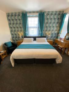 a bedroom with a large bed with blue curtains at Paignton Court in Paignton