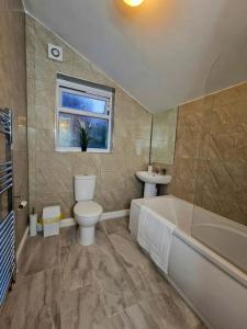 a bathroom with a tub and a toilet and a sink at Stunning 3 bedroom near NG Hospital in Sheffield