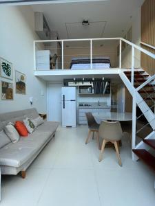 a white living room with a couch and a table at Ybira Loft in Araxá