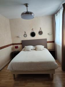 1 dormitorio con 1 cama blanca grande y 2 almohadas en LE SPORTING, en Beaumont-sur-Lèze