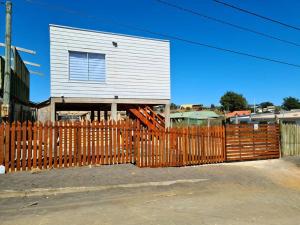 een houten hek voor een huis bij Acogedora cabaña en Pelluhue a metros de la playa in Pelluhue