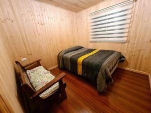 een slaapkamer met een bed en een raam in een kamer bij Acogedora cabaña en Pelluhue a metros de la playa in Pelluhue