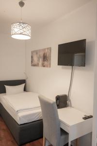 a bedroom with a bed and a desk and a tv at Hotel Teatro in Kassel