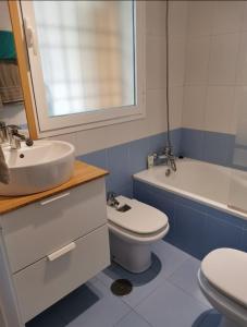 a blue and white bathroom with a sink and a toilet at Modern studio flat close to Plaza Merced in Málaga