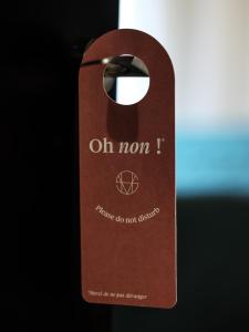 a brown door tag with the words oh mom i where do not believe at Seven Hotel in Paris