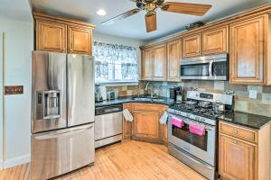 a kitchen with wooden cabinets and stainless steel appliances at Charming Elmsford Home about 23 Mi to Manhattan! in Elmsford +22 photos