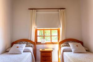 2 Betten in einem kleinen Zimmer mit Fenster in der Unterkunft One bedroom villa with sea view private pool and furnished garden at Tijarafe in Tijarafe