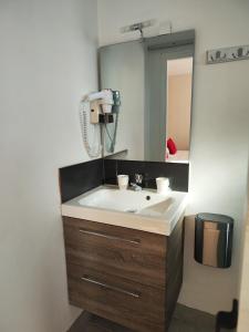 un bagno con lavandino e specchio di LE SPORTING a Beaumont-sur-Lèze