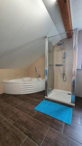 a attic bathroom with a shower and a tub at Rupp Ferienwohnung in Wallerfangen