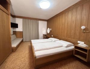 a hotel room with a bed and a tub and a bed and a room at Roter Adler in Caldaro