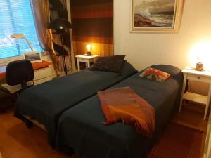a bedroom with two beds and a desk and a window at City Apartment Tulliportti in Kuopio