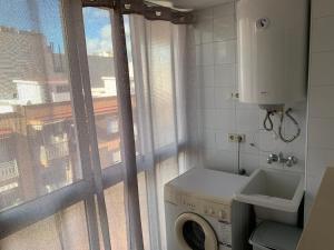 een kleine badkamer met een wasmachine en een raam bij Apartamento Sanchiz in Monóvar