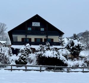 a large building with snow covered trees in front of it at Pension Lambrecht in Sankt Lambrecht