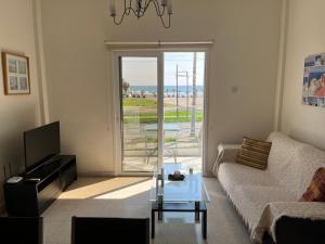 sala de estar con sofá y mesa de cristal en Themis Apartments, en Lárnaca