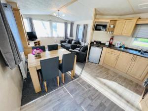 une cuisine et un salon avec une table dans une caravane dans l'établissement 3 Bedroom Caravan KG37, Dog Friendly, Shanklin, Isle of Wight, à Shanklin