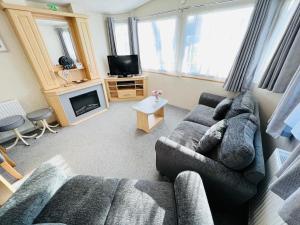 a living room with a couch and a tv at 3 Bedroom Caravan KG37, Dog Friendly, Shanklin, Isle of Wight in Shanklin