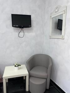 a room with a chair and a tv on a wall at Savastano house in Naples