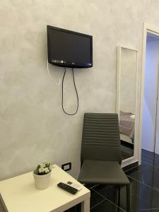 a room with a chair and a tv on the wall at Savastano house in Naples