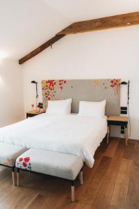 two beds in a room with white walls and wooden floors at Indrani Lodge in Loupoigne