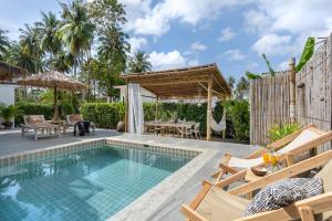 une piscine avec des chaises et une terrasse avec une table dans l'établissement Manao Pool Villa 3 - 5 Mins Walk To The Beach, à Ko Lanta