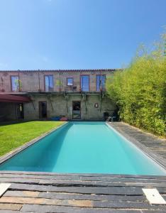 una grande piscina blu di fronte a un edificio di Alijó Douro House ad Alijó