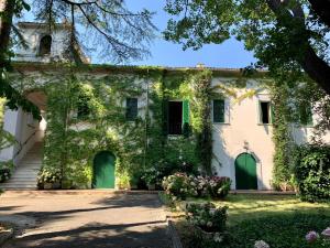 an ivycovered building with green doors and flowers at Aurora Holiday House in Vasto