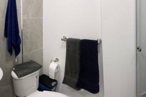 a bathroom with a toilet and two towels on the wall at Dpo 2 dorm(parqueadero wifi Netflix)vista pan. UIO in Quito +30 photos