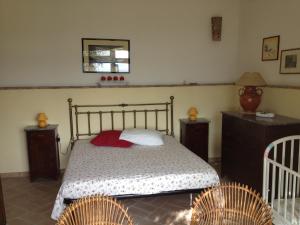 a bedroom with a bed with two tables and two chairs at Agriturismo Borgo Laurice in Torgiano