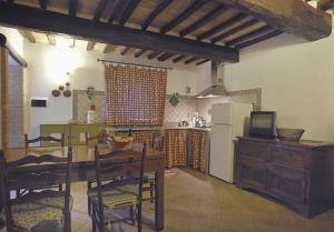a kitchen with a table and a refrigerator at Agriturismo Borgo Laurice in Torgiano