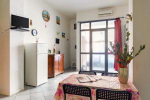 cocina y comedor con mesa y nevera en Essenza Holiday House - Florence - By HOST4U, en Florencia
