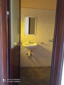 a bathroom with a sink and a shower with a mirror at Palm Star Motel in Fort Portal