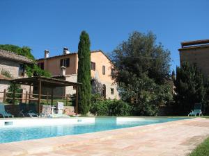 a swimming pool in front of a building at Agriturismo Borgo Laurice in Torgiano